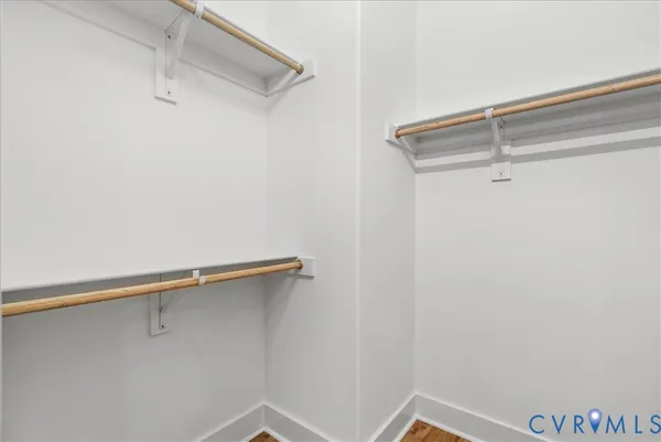 a kitchen with granite countertop a stove a sink and white cabinets with wooden floor next to windows