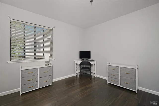 a view of a workspace with furniture and a window