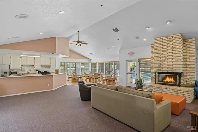 a living room with fireplace furniture and a large window