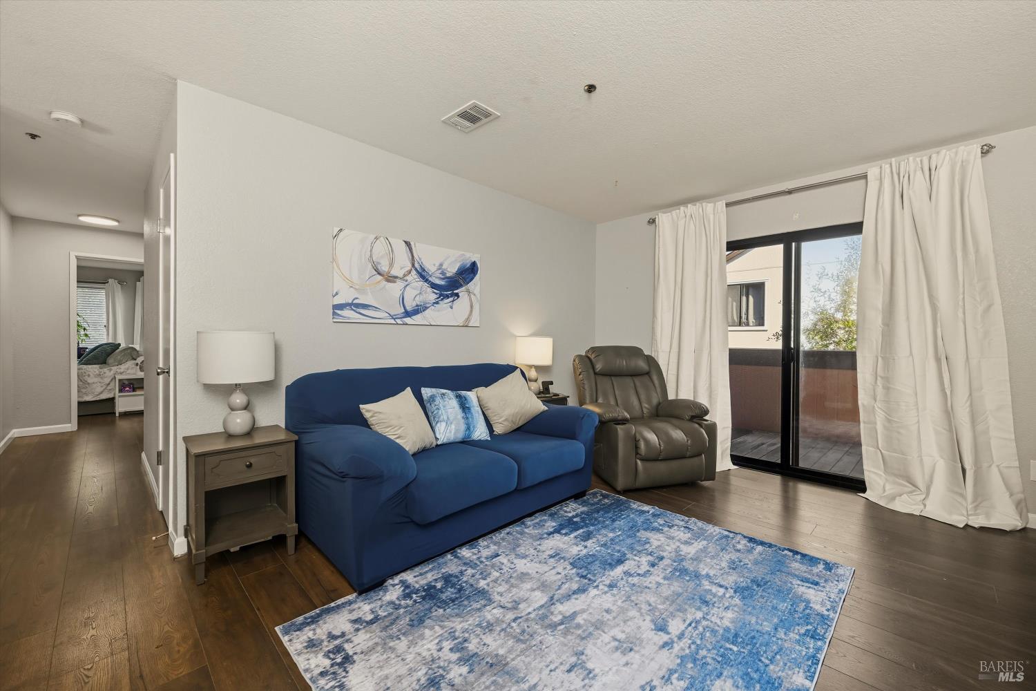 8201 Camino Colegio, Unit 122 Rohnert Park, CA 94928 - Photo 4 of 27 a living room with furniture a wooden floor and a large window