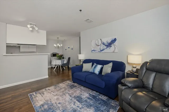 a living room with furniture and a wooden floor