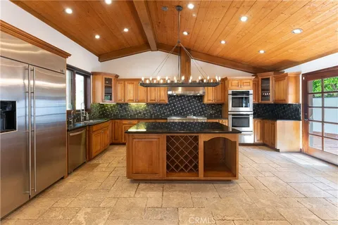 a large kitchen with stainless steel appliances kitchen island granite countertop a large counter top and cabinets