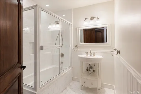 a bathroom with a bathtub shower sink and mirror