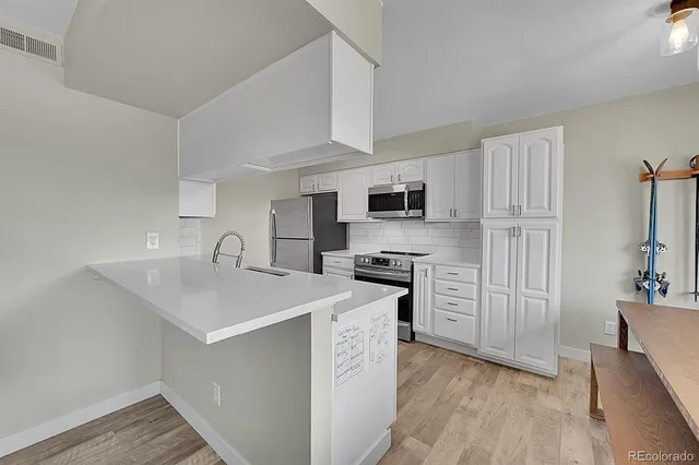 a kitchen with stainless steel appliances a sink stove refrigerator and cabinets