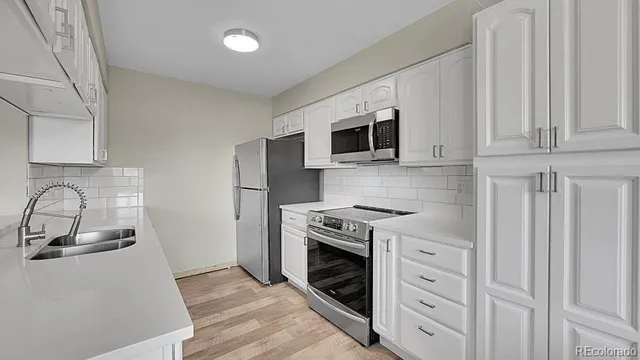a kitchen with appliances a sink and a stove