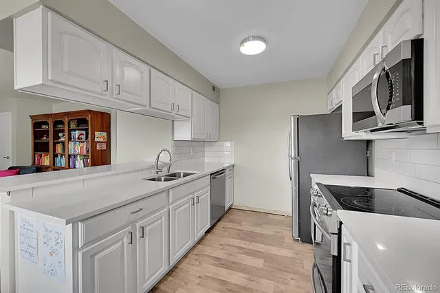 a kitchen with stainless steel appliances granite countertop a sink and a stove