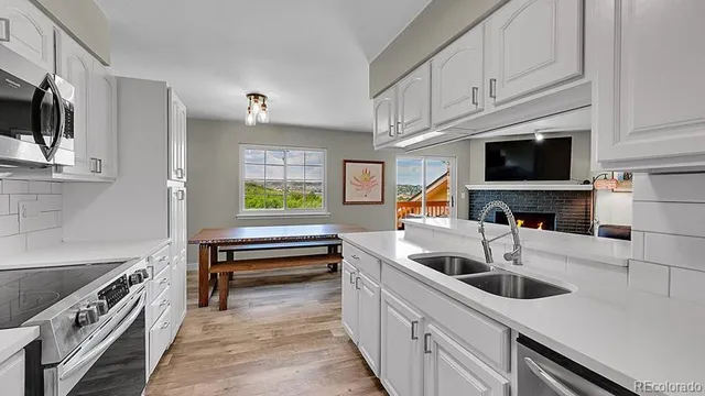 a kitchen with stainless steel appliances a stove a sink and a microwave