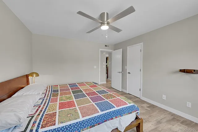 a bedroom with a bed and a lamp on a dresser