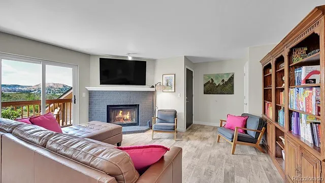 a living room with furniture bookshelf and a fireplace