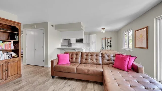 a living room with furniture cabinets and wooden floor