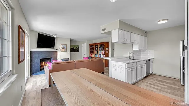 a kitchen with a refrigerator oven a sink dishwasher and white cabinets with wooden floor
