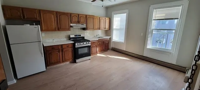 a kitchen with stainless steel appliances granite countertop a refrigerator sink and stove