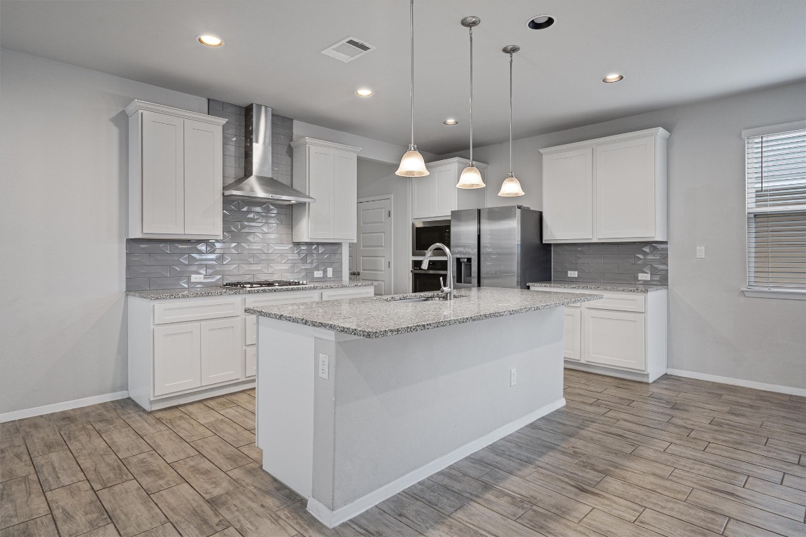 300 Delta Crest Maxwell, TX 78656 - Photo 8 of 36 a kitchen with kitchen island granite countertop a sink cabinets and wooden floor