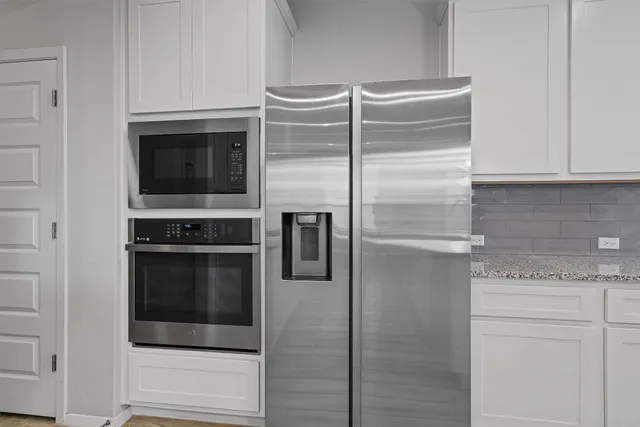 a kitchen with kitchen island granite countertop a sink cabinets and wooden floor