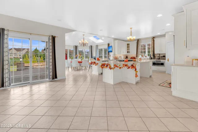 a dining room with wooden floor a chandelier a wooden table and chairs