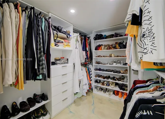 a view of walk in closet with clothes and shoes