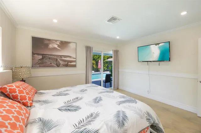 a bedroom with a large bed and a flat screen tv