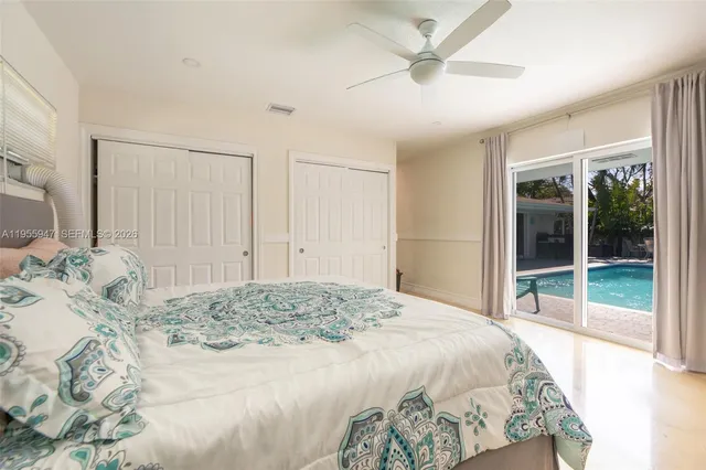 a spacious bedroom with a large bed and a chandelier fan