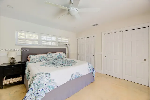 a large bed sitting in a bedroom next to a window and a chandelier