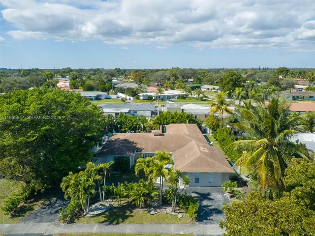 an aerial view of a house with garden space and lake view in back