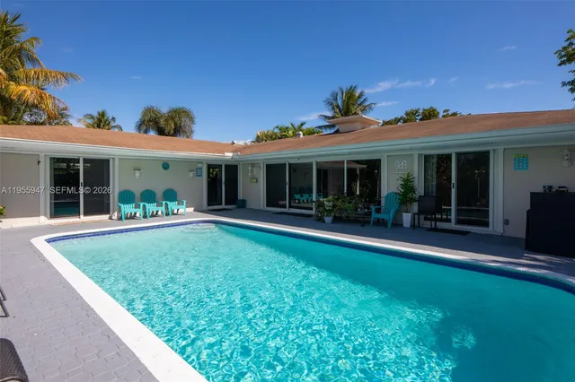 a view of backyard with table and chairs a barbeque and a large trees with a tree