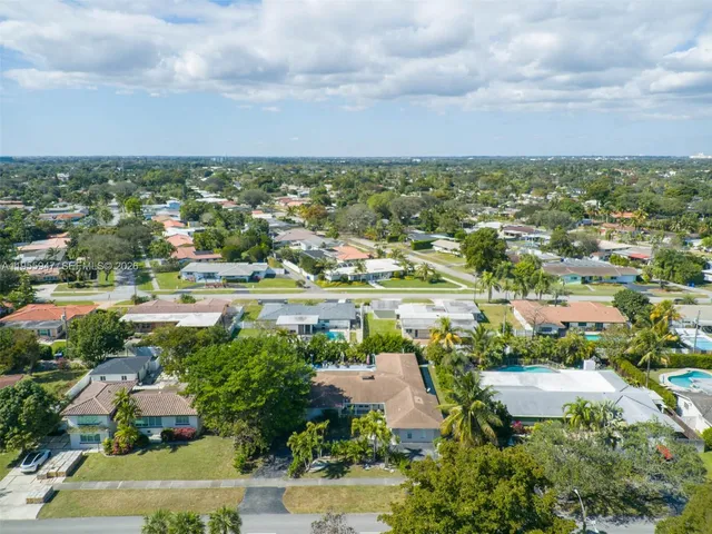an aerial view of a city with lots of residential buildings ocean and mountain view in back