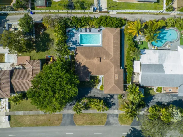 an aerial view of a house with a garden and lake view