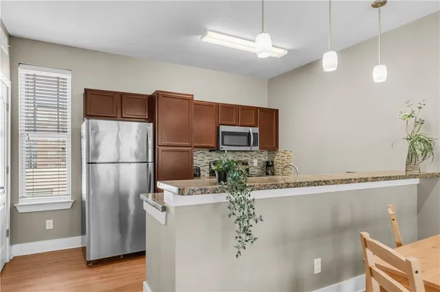a kitchen with stainless steel appliances granite countertop a refrigerator a sink and a stove