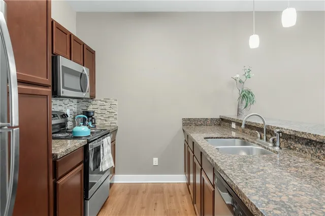 a kitchen with stainless steel appliances granite countertop a sink stove and refrigerator