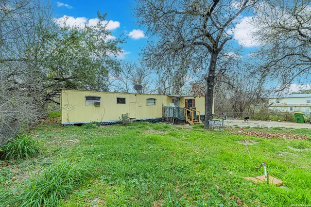 a view of backyard with house and trees
