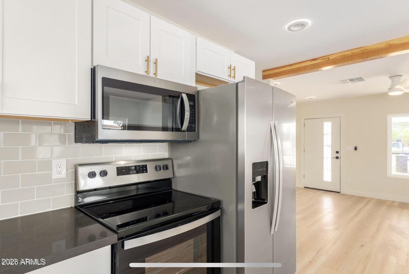 902 East Fairmount Avenue Phoenix, AZ 85014 - Photo 17 of 28 a kitchen with stainless steel appliances a stove a microwave and a hard wood floor