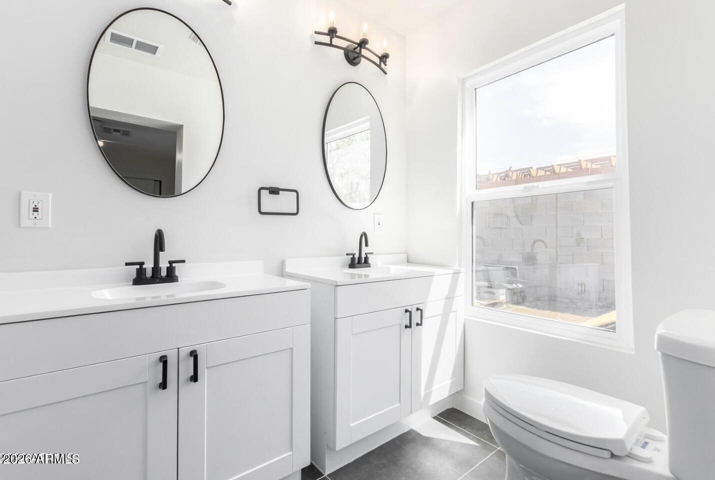 902 East Fairmount Avenue Phoenix, AZ 85014 - Photo 22 of 28 a bathroom with a toilet a sink and a mirror
