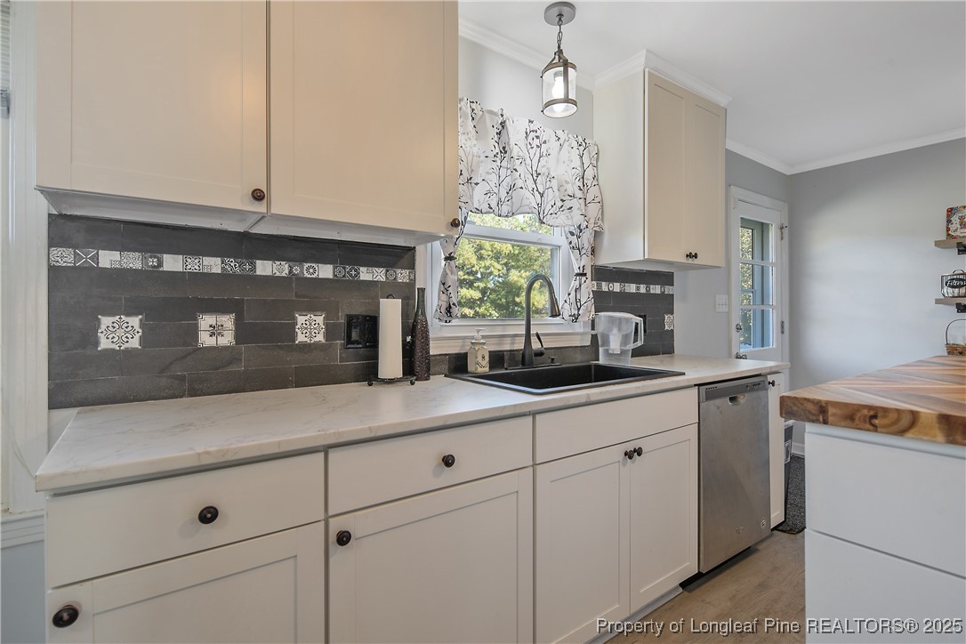7666 Overhills Road Spring Lake, NC 28390 - Photo 17 of 50 a kitchen with stainless steel appliances white cabinets and a fireplace