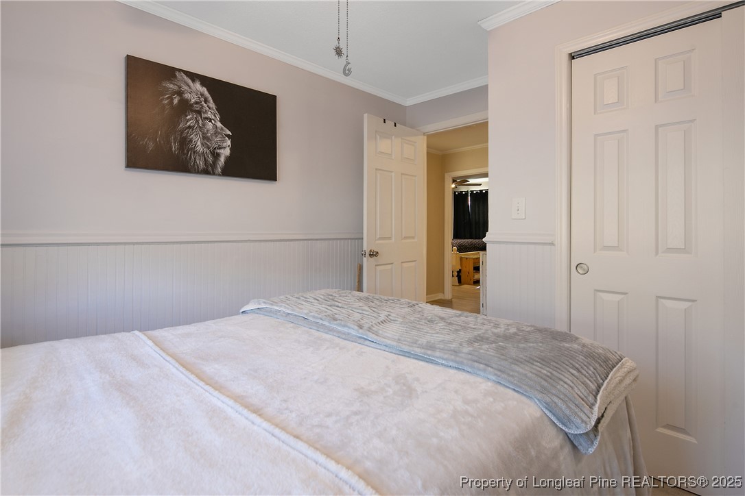 7666 Overhills Road Spring Lake, NC 28390 - Photo 34 of 50 a bedroom with a large bed and painting on the wall