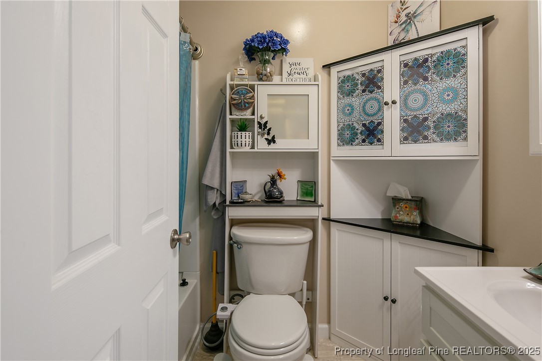 7666 Overhills Road Spring Lake, NC 28390 - Photo 35 of 50 a bathroom with a toilet a sink and a window