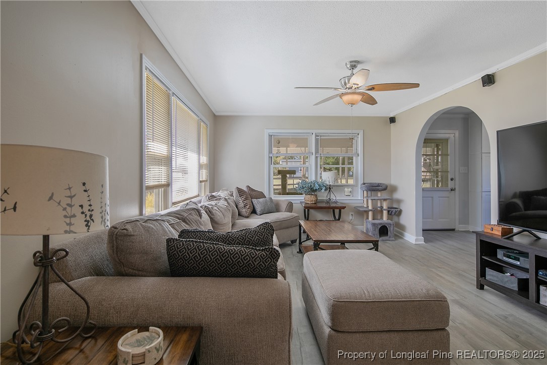 7666 Overhills Road Spring Lake, NC 28390 - Photo 7 of 50 a living room with furniture a large window and a chandelier