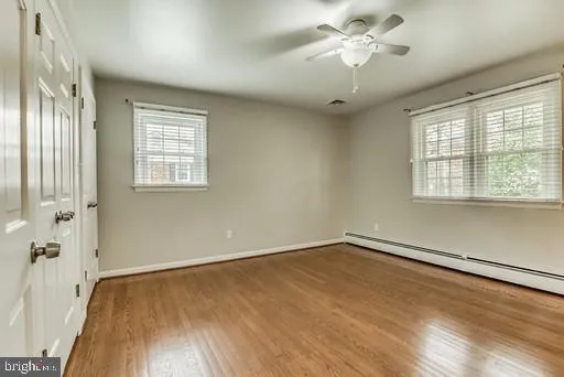 a view of an empty room with wooden floor