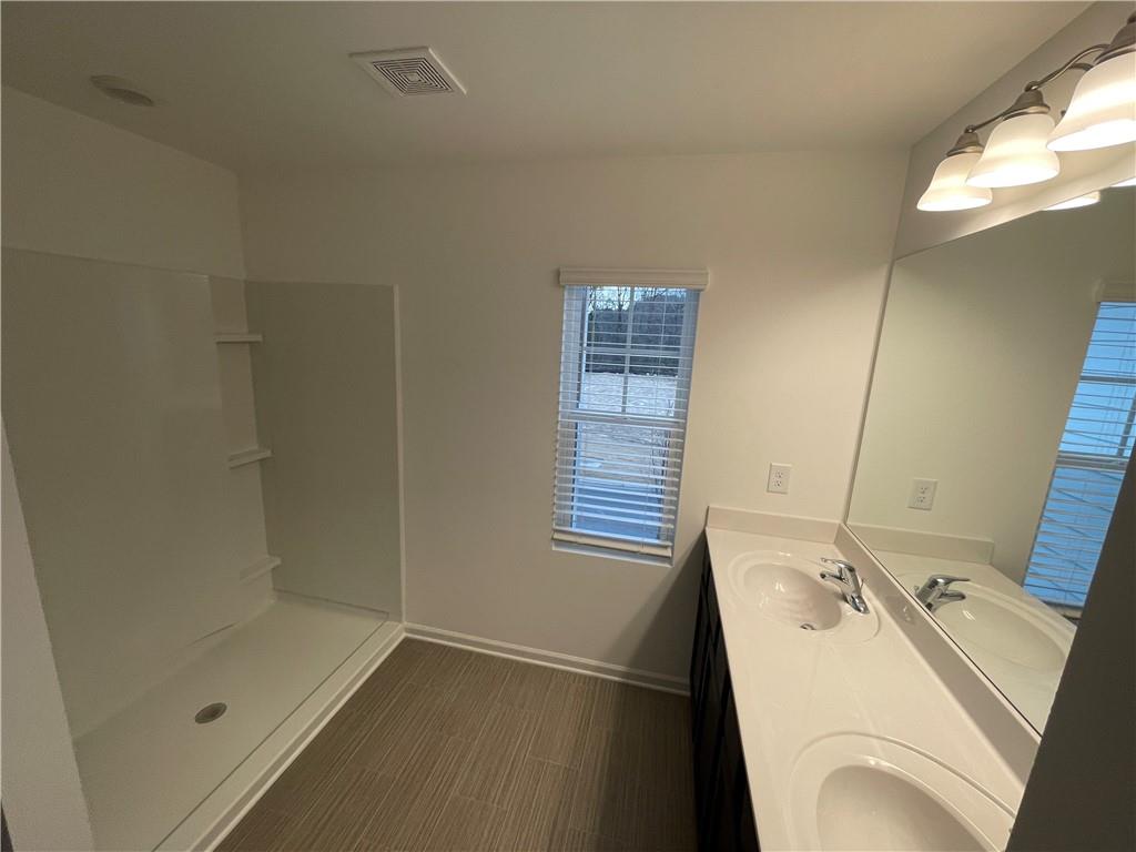 1003 Ramon Drive Grayson, GA 30017 - Photo 11 of 12 a bathroom with a sink and a shower