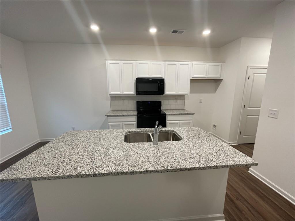 1003 Ramon Drive Grayson, GA 30017 - Photo 4 of 12 a kitchen with granite countertop kitchen island a sink a stove and a refrigerator