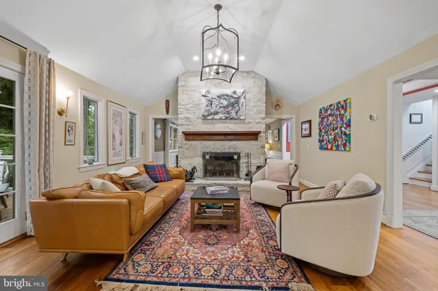 a living room with furniture a fireplace and a chandelier
