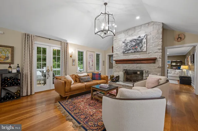 a living room with furniture a chandelier and a fireplace