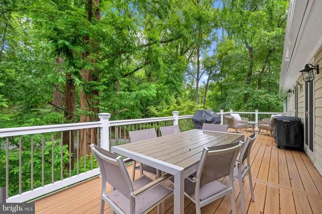 a balcony with wooden floor table and chairs