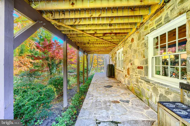 a view of a house with large trees and a wooden deck