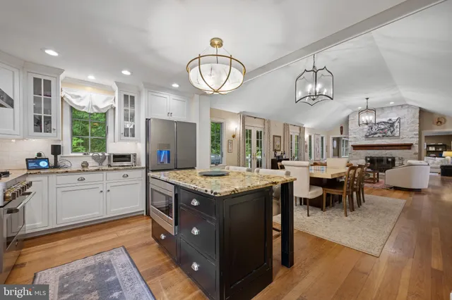 a kitchen with stainless steel appliances granite countertop a stove and a large refrigerator