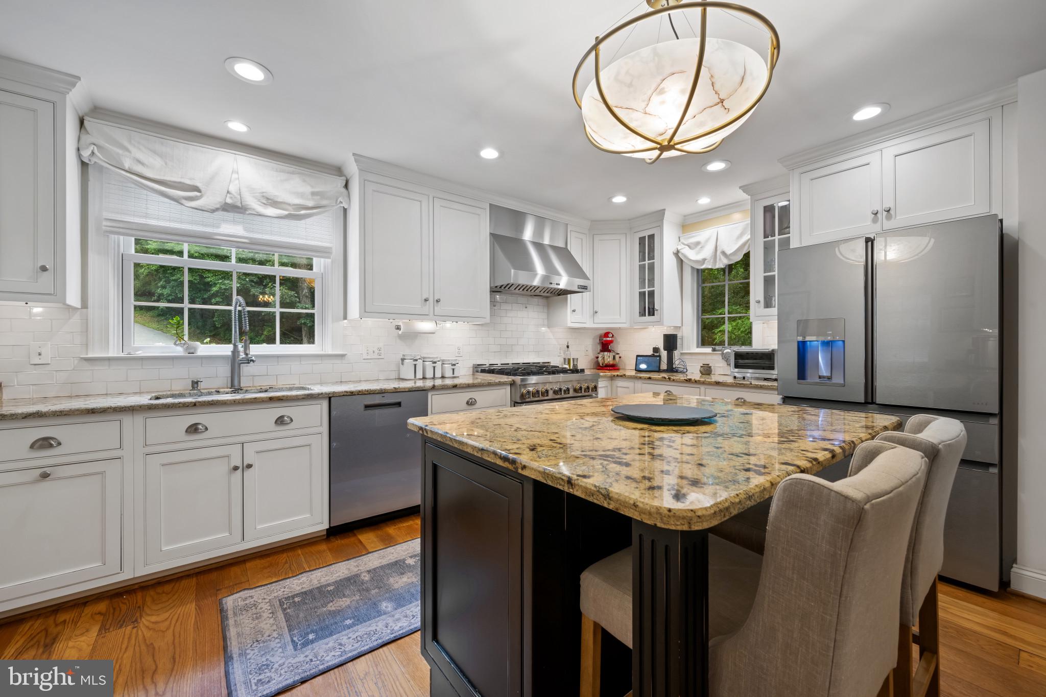 901 Navy Road Baltimore, MD 21204 - Photo 8 of 40 a kitchen with stainless steel appliances granite countertop a kitchen island a stove a sink a dining table and chairs