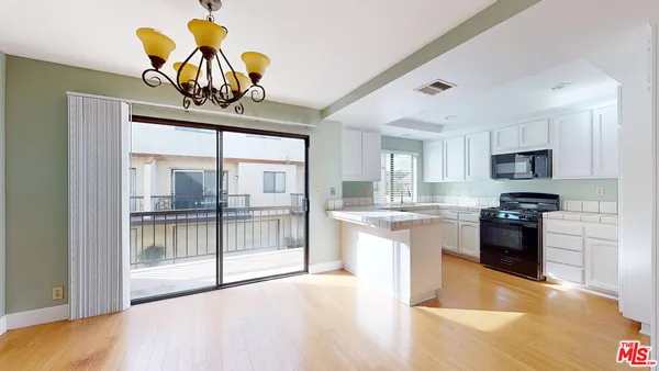 a kitchen with stainless steel appliances granite countertop a refrigerator a stove a sink and a wooden floors