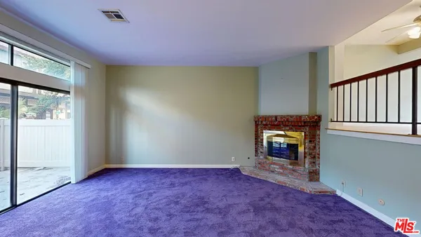 a view of an empty room with a fireplace and a window