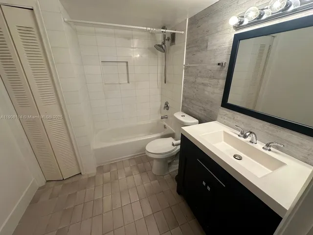 a bathroom with a sink a toilet a mirror and shower