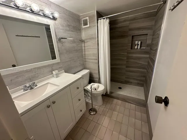 a bathroom with a double vanity sink toilet and shower