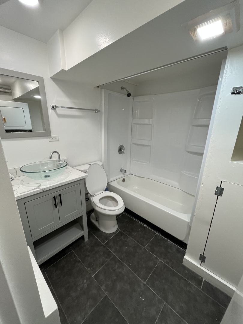 1922 South Springfield Avenue, Unit G Chicago, IL 60623 - Photo 9 of 10 a bathroom with a double vanity sink a toilet and a mirror